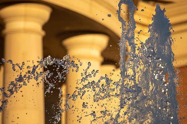 Water flies through the air above a fountain.